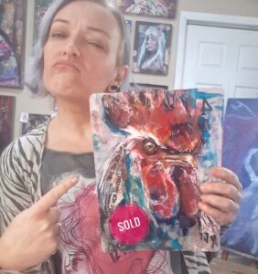 Sara Leger Holding a SOLD sassy Bird painting from her Facebook Studio Sale.