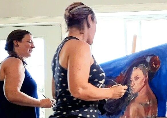 Two artists painting at Cherry Bomb Studio Gallery in Lancaster at an Open Studio event