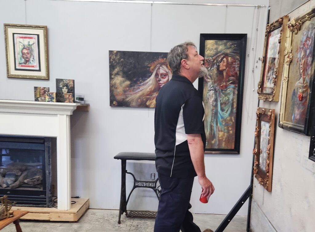 Art collector at Cherry Bomb Studio in Lancaster looking at art by sara Leger