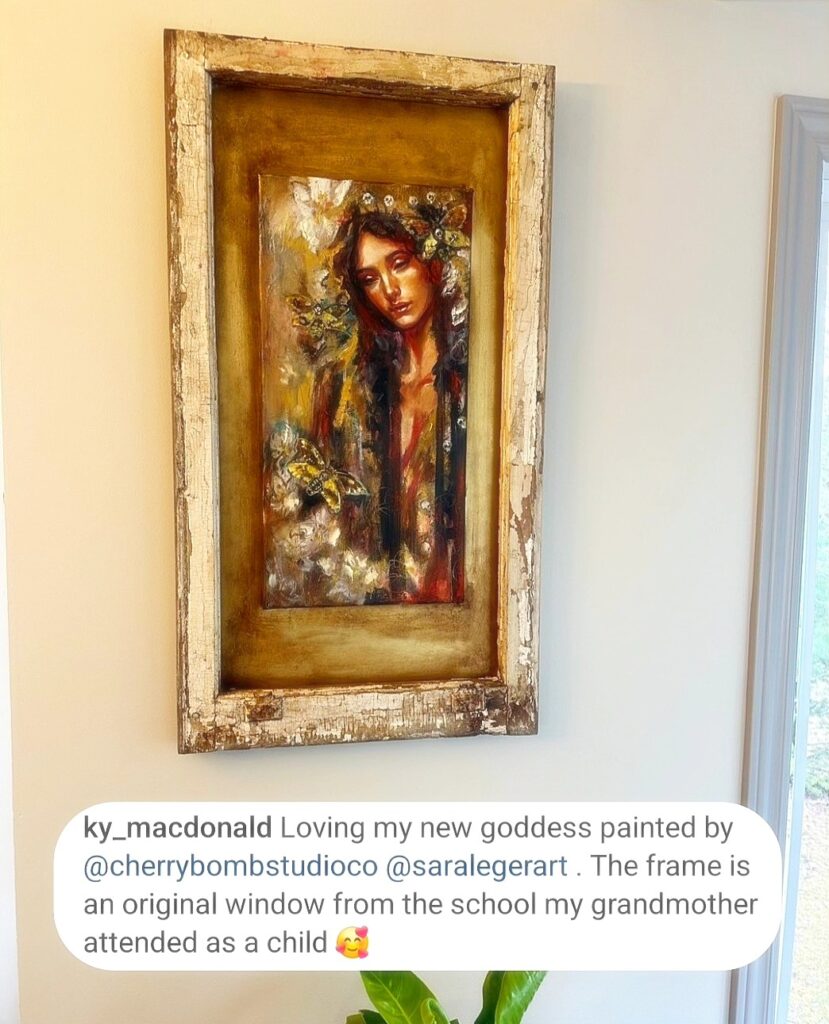 Sacred heart painting by sara leger of a woman looking down her black hair drips and and is adorned with a gold roses with a skull