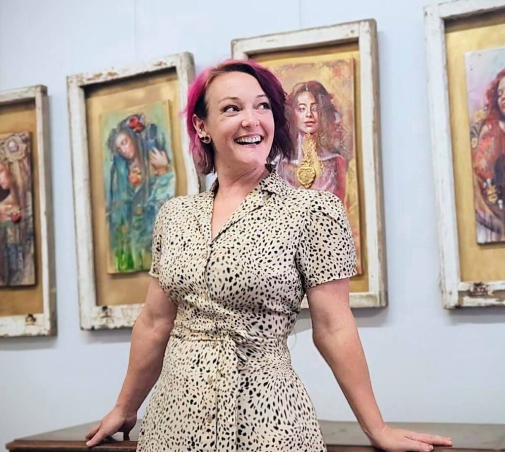Sara Leger standing in front of her sacred heart paintings