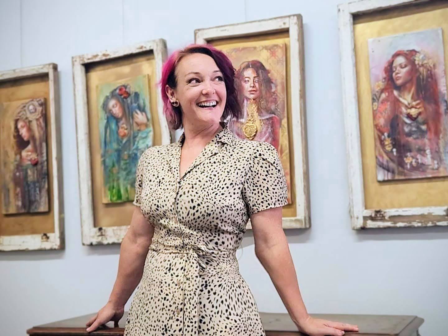 Sara Leger standing in front of her sacred heart paintings